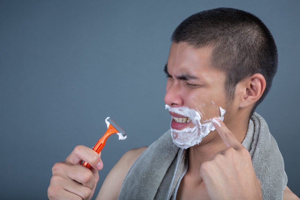 Man experiencing irritation while shaving
